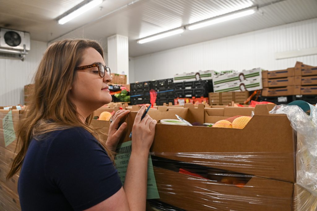 Katie Adkins looks over the supply in the refrigerated storage area at The Food Bank for Central & Northeast Missouri | Maya Bell