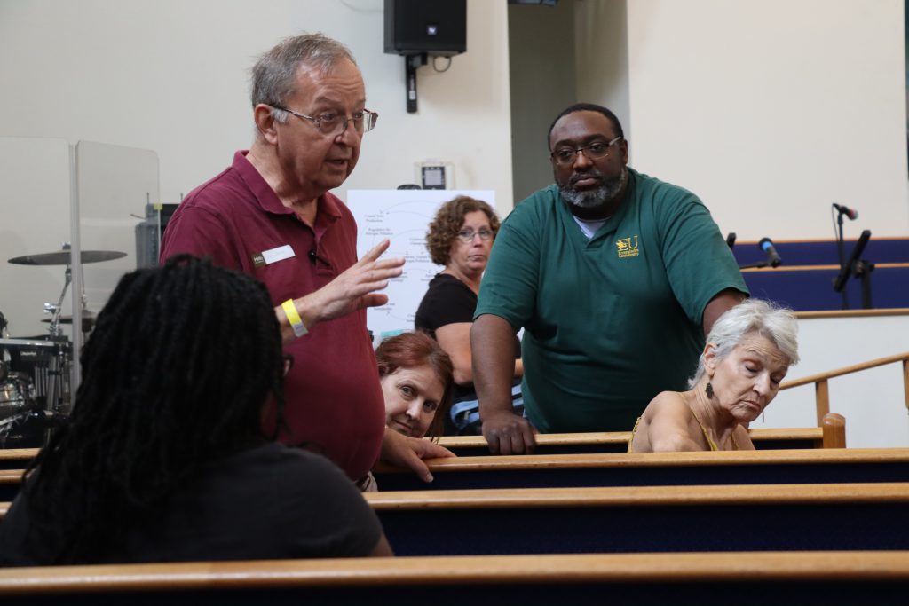 Walter Smith II (right) listens to community presenters at the Progress Village Environmental Health Fair at the Victory African Methodist Episcopal Church Saturday, April 22, 2023. (Alan Halaly/WUFT News)
