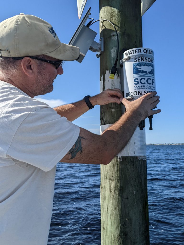 A.J. Martignette installs a RECON water quality sensor on the water 