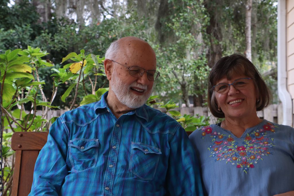 William and Lyuba Wharton share a moment outside their home in Gainesville. “I began to realize that she was beginning to sort of put down her own roots,” he said. “I thought: I don’t think I want her to do that – so I asked her to marry me.” (Anna Wilder/WUFT News)