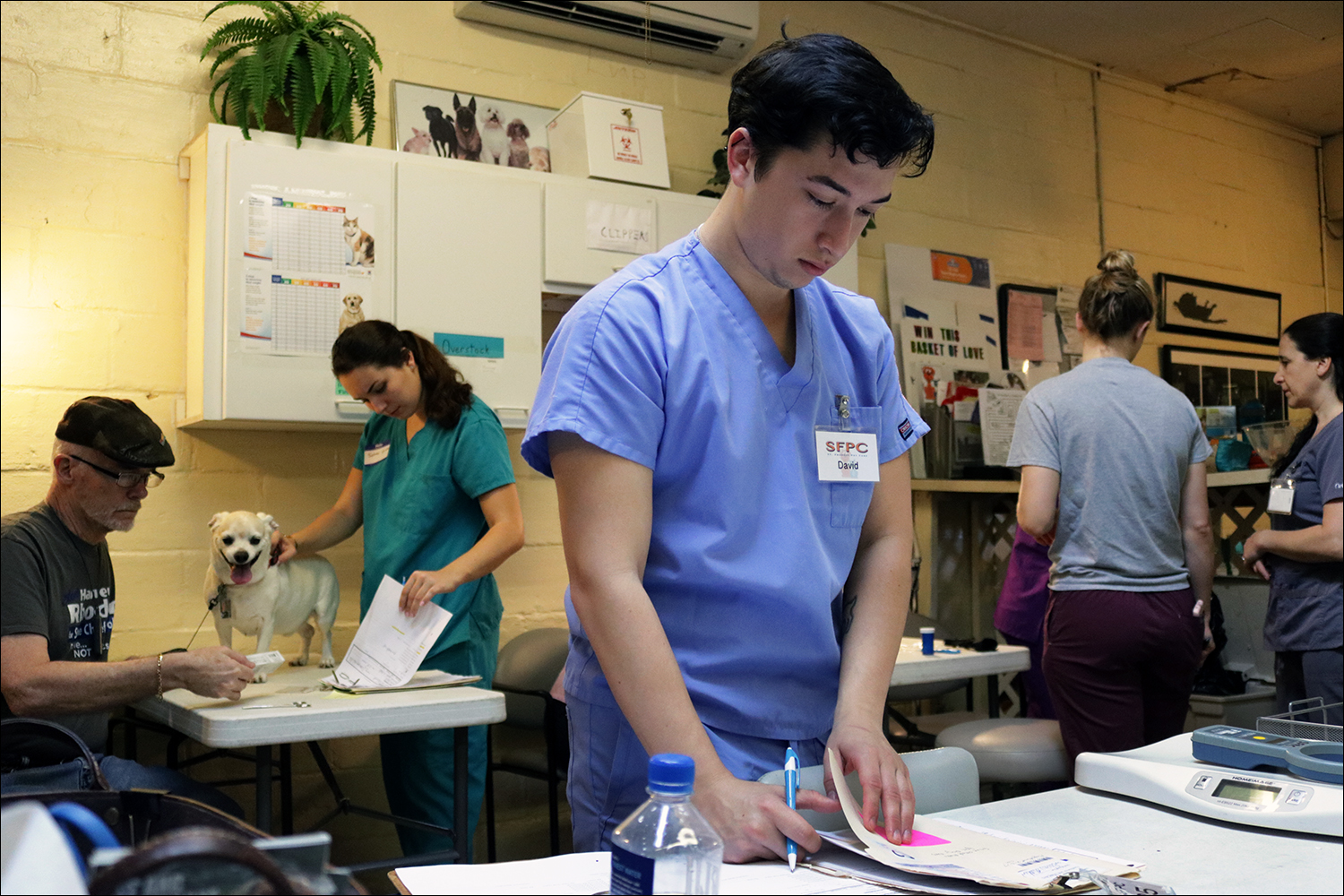 St. Francis volunteer David Rodriguez, 23, fills out paperwork as he starts his day at the clinic. (Kaitlin Hall/WUFT News)