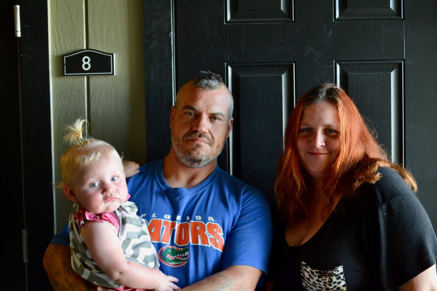 Sandy, Millie and baby Sandy stand outside their new apartment. (Monica Humphries/WUFT News)