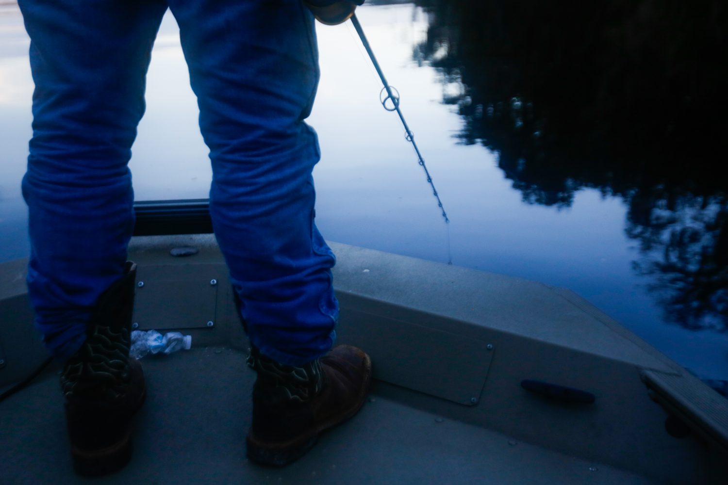 Richie Smith stands at the front of the boat looking closely at the water for signs of an alligator after previously spotting one nearby on October 26, 2019. (Chris Day/Fresh Take Florida)