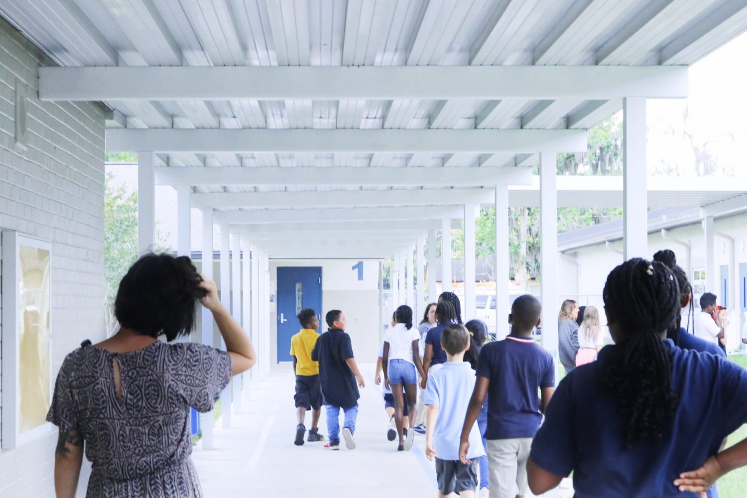 Peebles leads her students down the hall. She sometimes struggles to contain their energy outside the classroom.