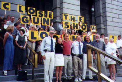 Tom in front of the “Close the Gun Show” sign with the SAFE Colorado volunteers. (Photo courtesy of Tom Mauser)